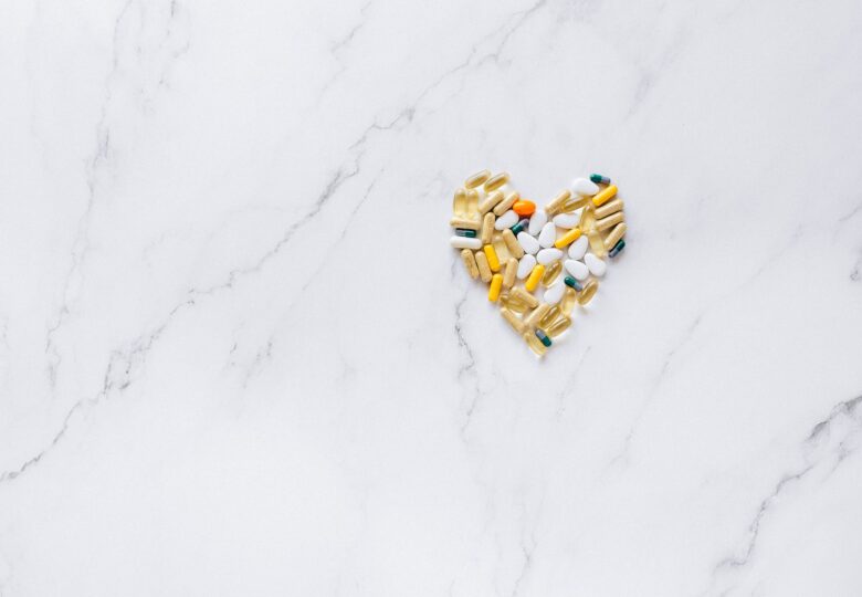 a heart shaped pills and medicines on a marble surface