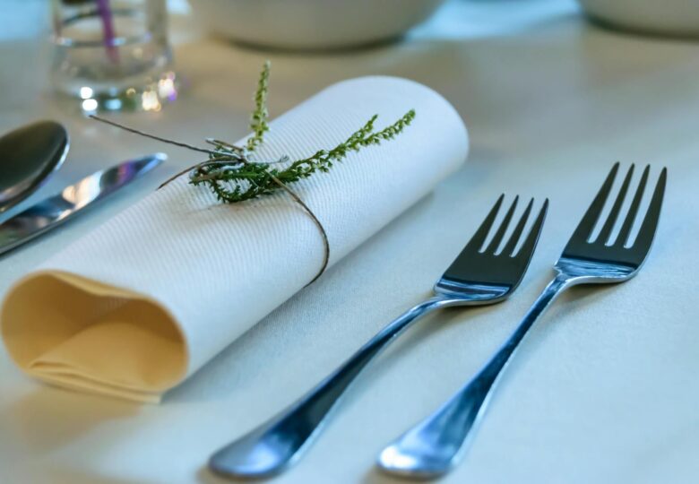 stainless steel fork beside rolled paper towel with parsley on top