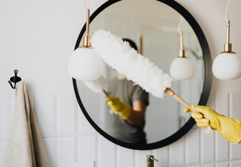 crop woman dusting lamp during housework