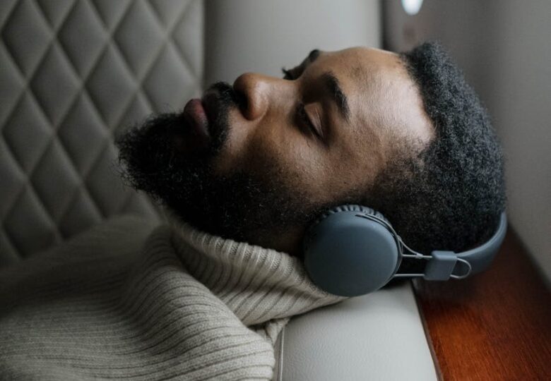 man in gray sweater wearing white headphones